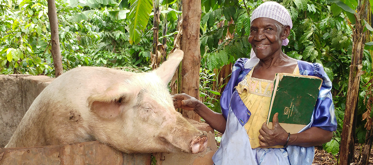 African lady with a pig near Jinja, Uganda